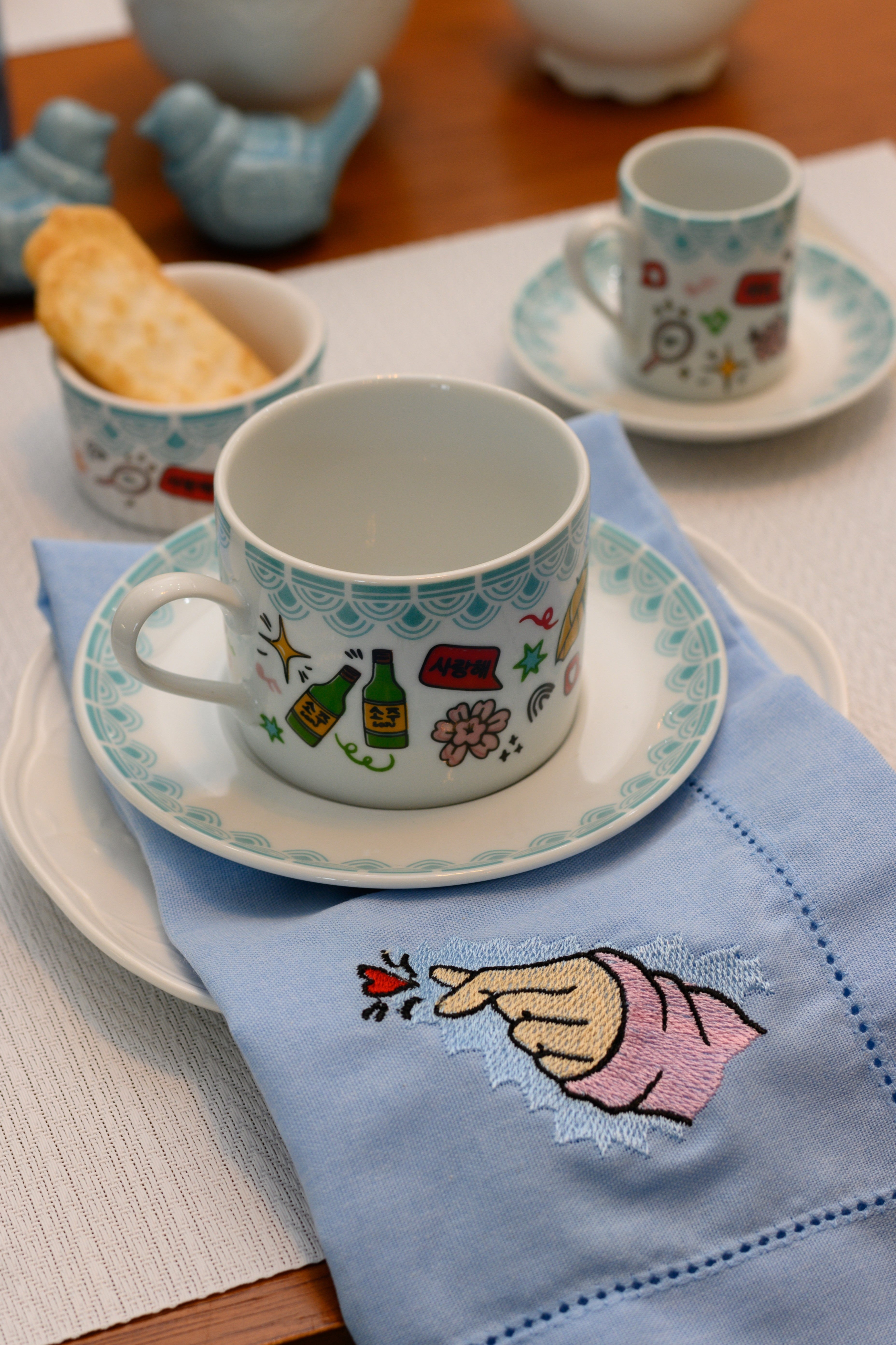 XICARA DE CHÁ EM CERÂMICA COREANA ACABAMENTO AZUL ESTAMPA DIVERSA C/ PIRES 230ML  SHIMIDT