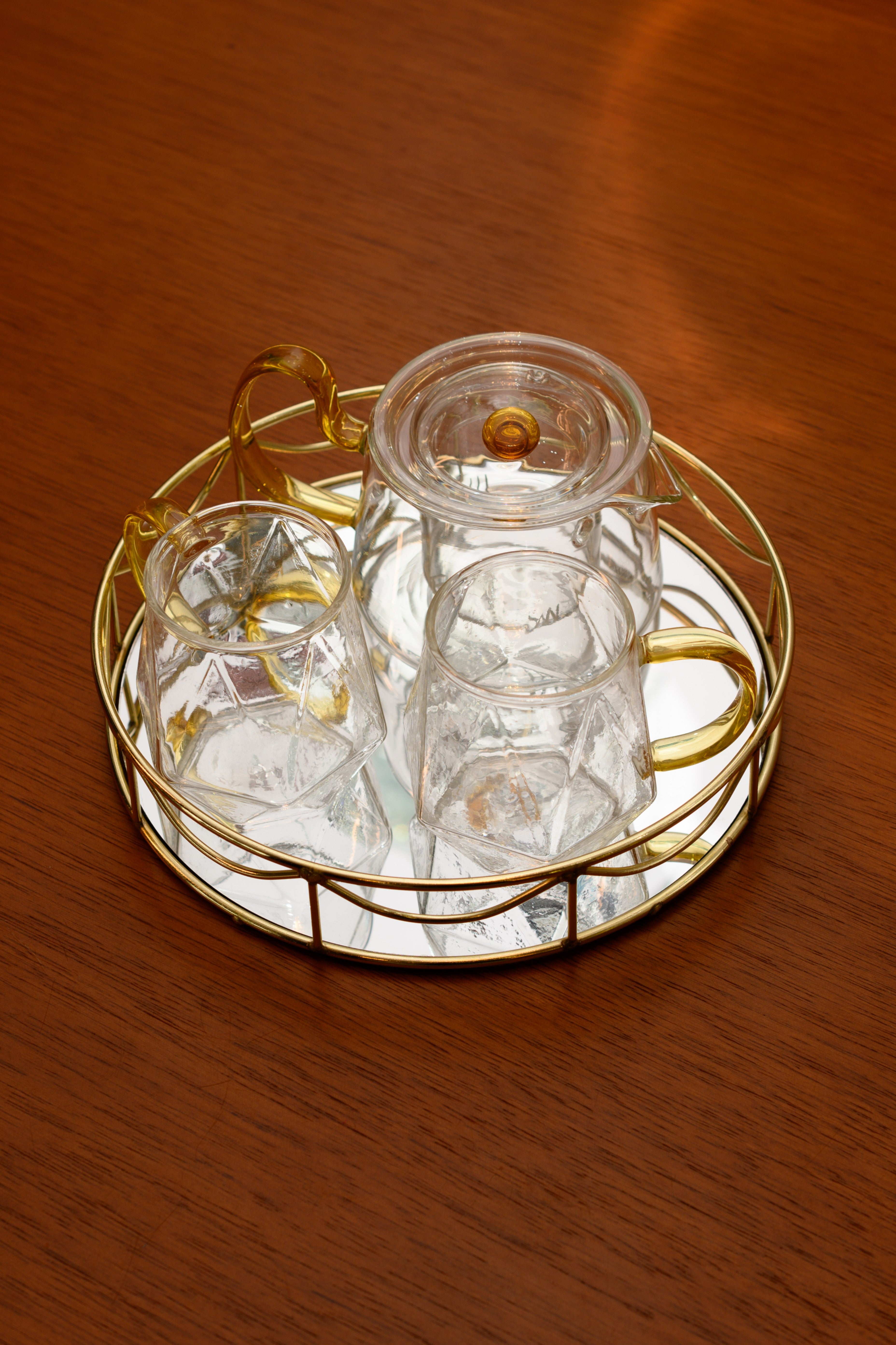 KIT COREANO CHALEIRA CANECAS BOROSSILICATO TRANSPARENTE ALÇA AMARELA C/ BANDEJA REDONDA DOURADA ESPELAHADA 04PÇS – DBL